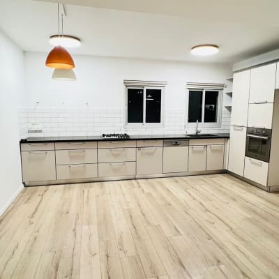 מטבח נקי עם רצפת עץ ותאורה מודרנית