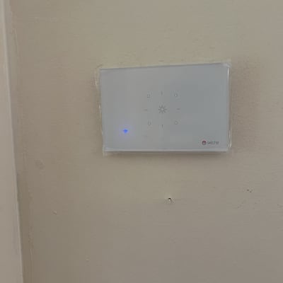 מתג חשמלי חכם עם חיווי כחול על קיר