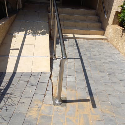 מעקה מתכת לאורך רמפה ומדרגות בכניסה