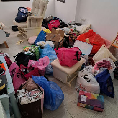 חדר עם שקיות וארגזים, מראה של בלגן לפני סידור.