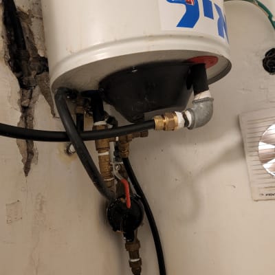 דוד שמש עם צינורות וחיבורים על קיר