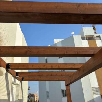 קורות עץ חומות מותקנות על מבנה חיצוני