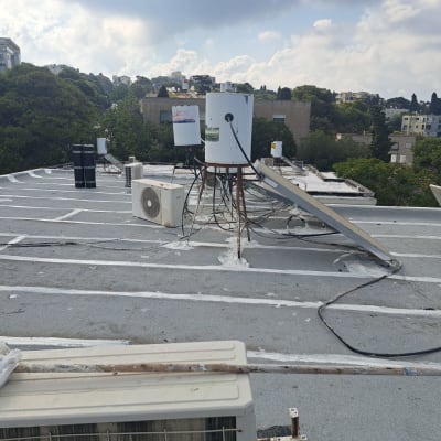 גג עם קווים לבנים לאיטום וציוד טכני