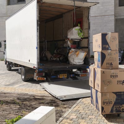 משאית פתוחה עם קרטונים וציוד מעבר