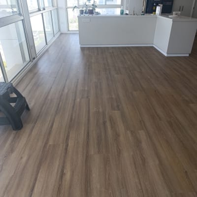 רצפת פרקט עץ חום בחדר מואר עם חלונות גדולים