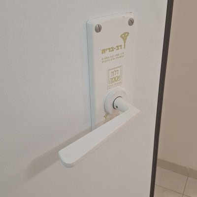 ידית דלת עם מנעול על דלת לבנה