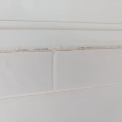 אריחי קרמיקה לבנים עם רובה מתקלפת