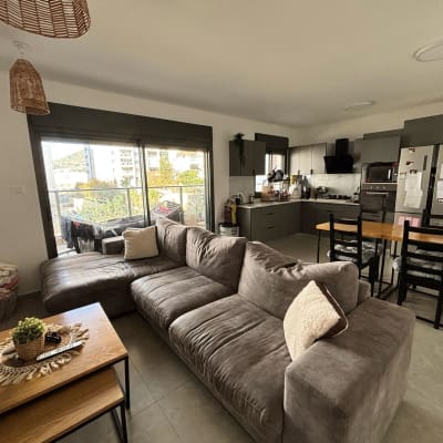 ספה אפורה עם כריות בסלון מואר