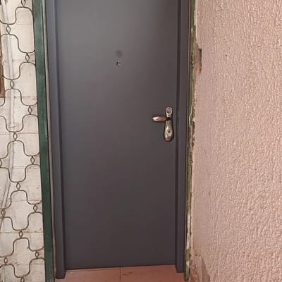 דלת מתכת אפורה עם ידית כסופה