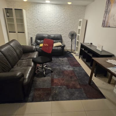 סלון עם ספה, כיסא משרדי, שולחן ומאוורר עומד