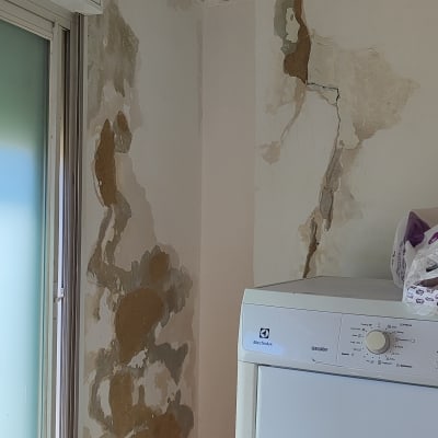 קיר מתקלף עם סולם ומכונת כביסה