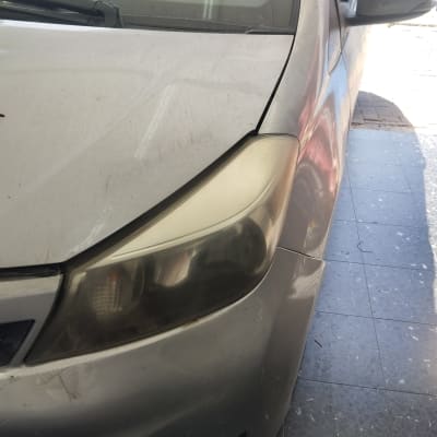 פנס קדמי של רכב עם לכלוך על מכסה המנוע