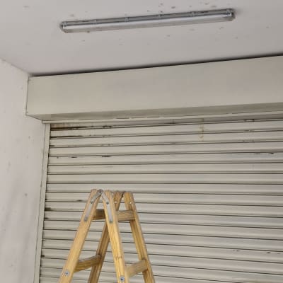 סולם עץ מתחת למנורת פלורסנט בתקרה