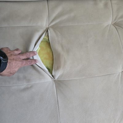 קרע בריפוד ספה עם חומר מילוי גלוי