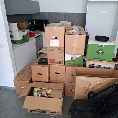 קופסאות קרטון לאריזה במטבח עם מוצרי ניקוי