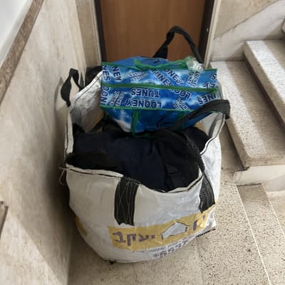 שקיות עם חפצים ליד דלת כניסה