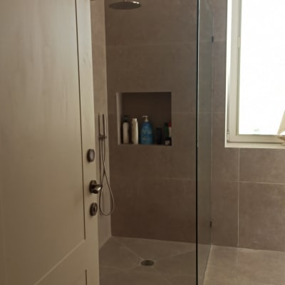 מקלחת עם ראש גשם ומדף בקיר