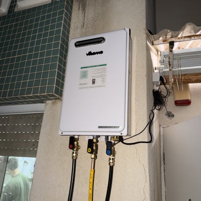 מחמם מים מותקן על קיר עם צינורות חיבורים