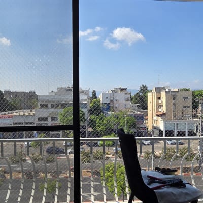 נוף עירוני מבעד לחלון עם רשת הגנה