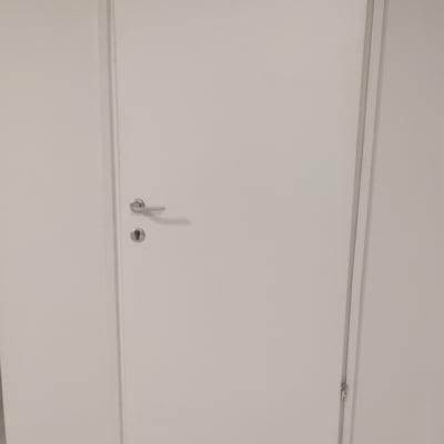 דלת לבנה עם ידית כסופה על קיר גבס