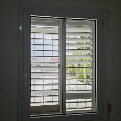 חלון אלומיניום עם תריסים נראים מבחוץ