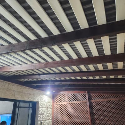 תקרת עץ עם קורות חומות ולוחות לבנים