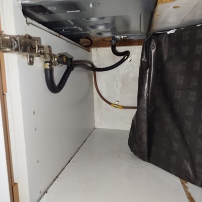 צינורות גז ומחברים מתחת לכיריים במטבח