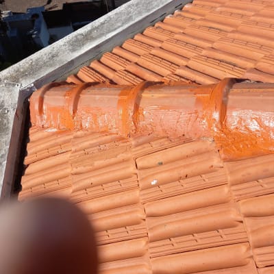 תמונה של גג רעפים עם תיקון בטיט כתום