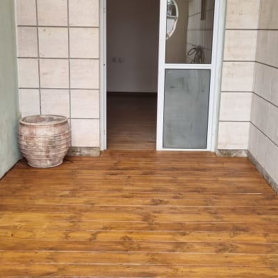 רצפת עץ חומה עם דלת זכוכית ומסגרת לבנה