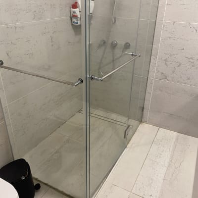 מקלחון זכוכית עם ראש מקלחת ומוצרי טיפוח