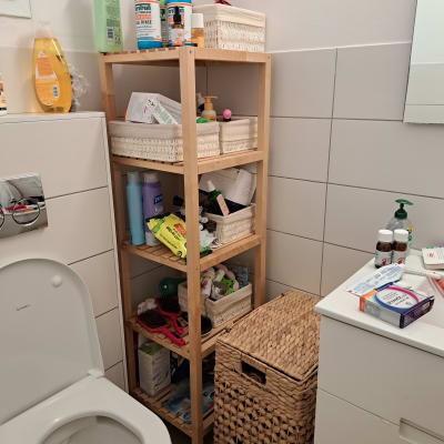 מדפים עם מוצרי טיפוח וסל כביסה בחדר אמבטיה