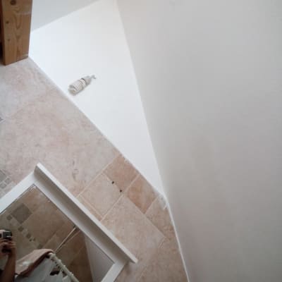 קיר צבוע בלבן עם גליל צבע על הרצפה