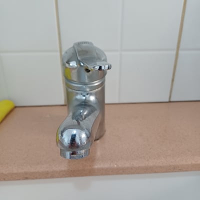 ברז כרום על משטח מטבח עם אריחים לבנים