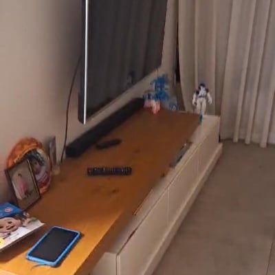 שלט רחוק על שולחן עץ ליד טלוויזיה