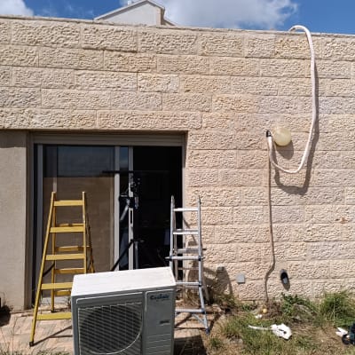 יחידת מיזוג אוויר עם סולמות ליד קיר חיצוני