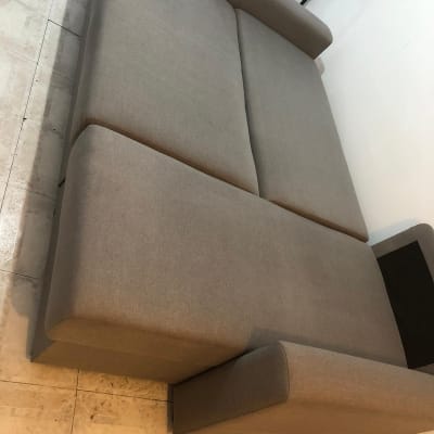 ספה אפורה על רצפה, ללא אנשים או טקסט.