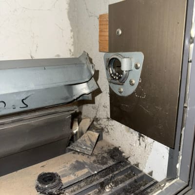 חלקי תריס שבור עם מסגרת מתכת וקיר סדוק