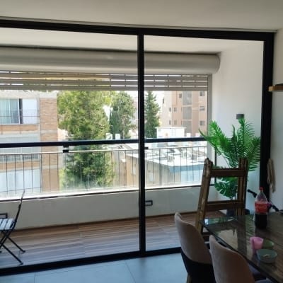 תריסים חיצוניים על חלון זכוכית גדול במרפסת