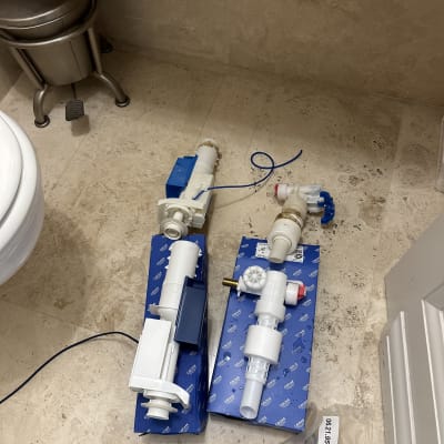 חלקי אינסטלציה לבנים על קופסאות כחולות על הרצפה