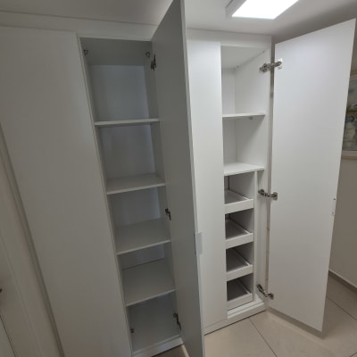 ארון לבן עם דלתות פתוחות ומדפים פנימיים