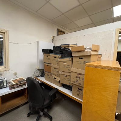 חדר עם קופסאות קרטון וציוד משרדי על שולחן