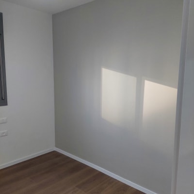 קיר צבוע בצבע אפור בהיר עם תאורה עליונה