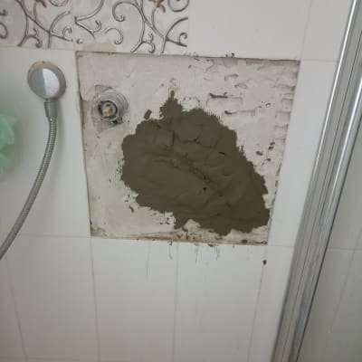 תיקון קיר במקלחת עם טיח ליד צינור מים