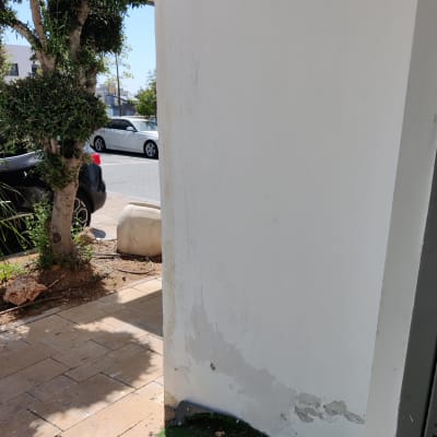 קיר לבן עם קילופי צבע בתחתית