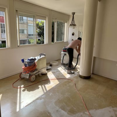 אדם מנקה רצפה עם מכונת פוליש וחומרי ניקוי