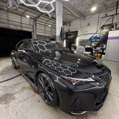 רכב שחור מבריק במוסך דיטיילינג עם תאורה ייחודית