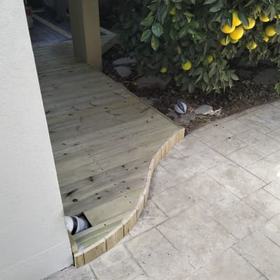 דק עץ ליד עץ פרי בגינה