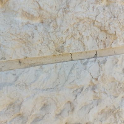 תקריב של קיר אבן עם סדקים קטנים