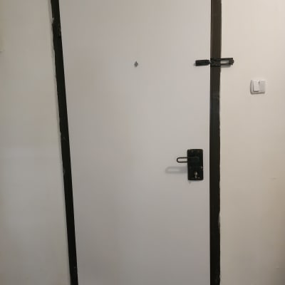 דלת לבנה עם מסגרת כהה ומנעול בריח