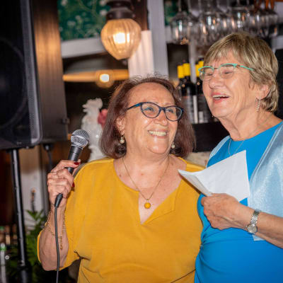 אישה מחזיקה מיקרופון ליד רמקול גדול